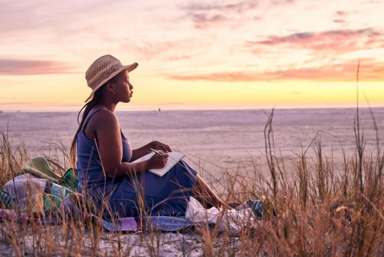 a woman sitting outside during a sunset