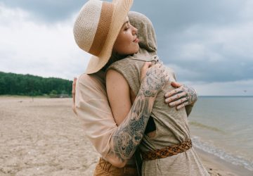 2 woman embracing each other at the beach