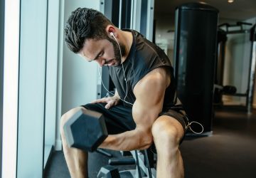 a man doing arm curls in the gym