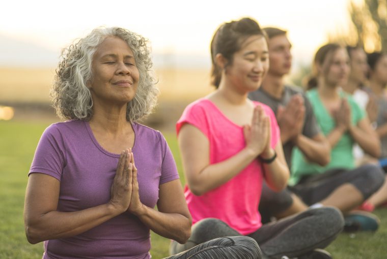 a group of seniors doing yoga outdoors