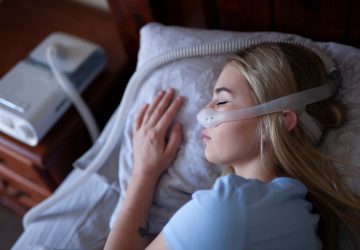 a woman sleeping with a CPAP machine