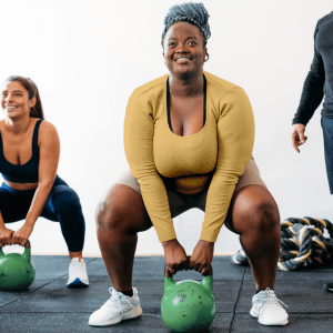 a pair of women using kettlebells