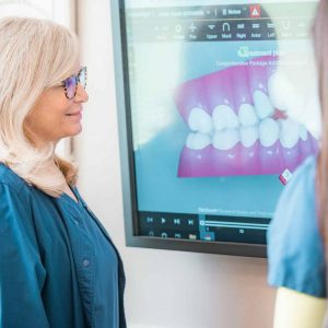 a woman looking at an image of braces