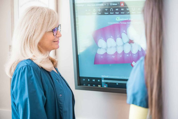 a woman looking at an image of braces