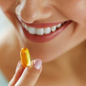 a woman taking an omega 3 supplement