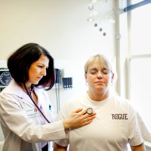 a doctor listening to a patients heart