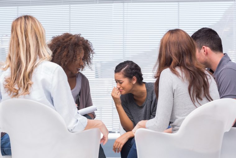a woman crying in a group therapy session.