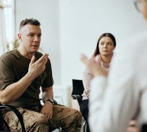 a man talking to a group in a therapy session.