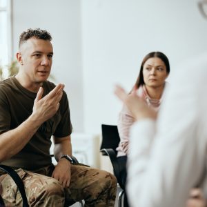 a man talking to a group in a therapy session.