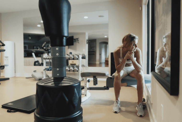 a woman in her gym looking out a window