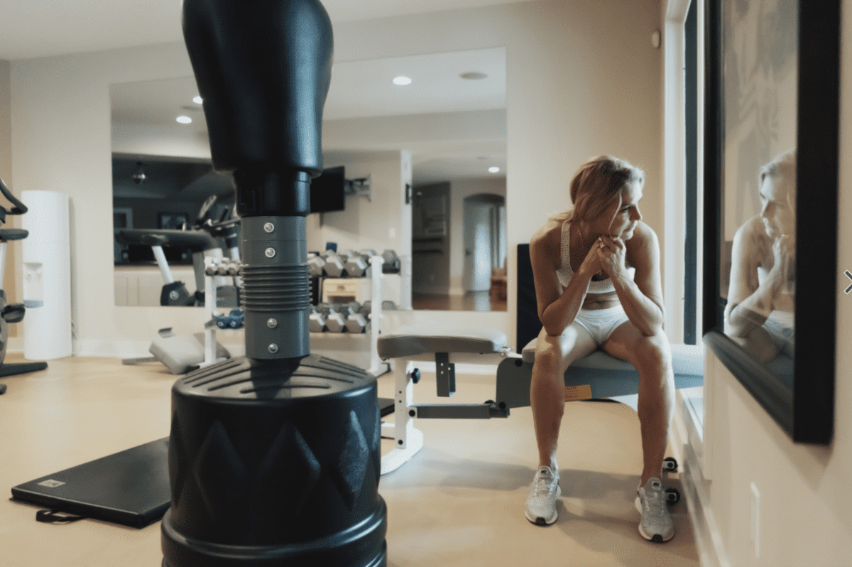 a woman in her gym looking out a window