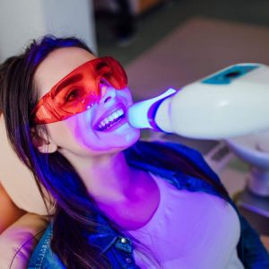 a woman receiving a teeth whitening service