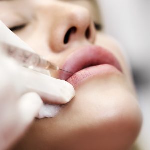 Professional cosmetologist making facial injection