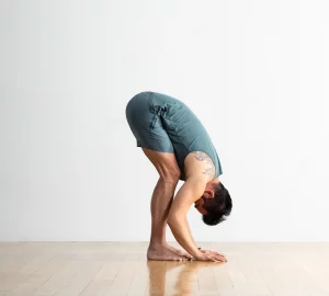 a man in a front fold yoga pose