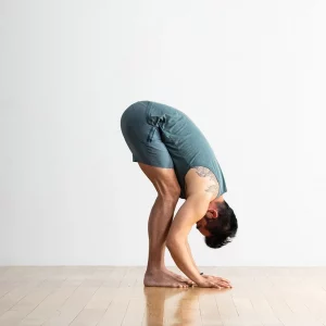 a man in a front fold yoga pose