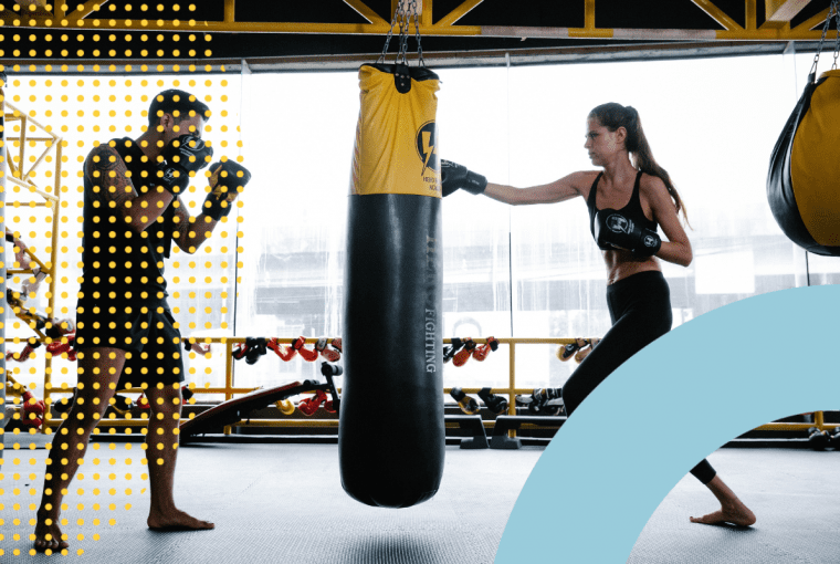 a trainer and a client hitting a heavy bag