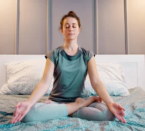 a woman meditating in bed