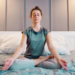 a woman meditating in bed