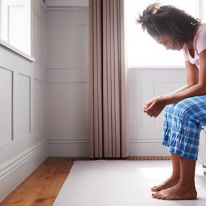 a woman sitting on the side of a bed