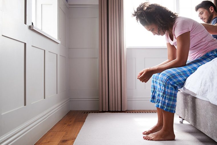 a woman sitting on the side of a bed