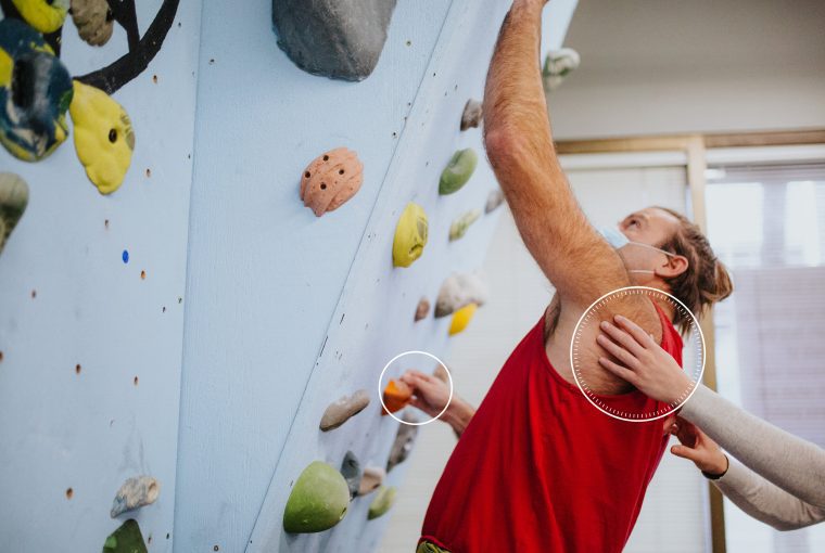 a man getting some support slimbing a wall