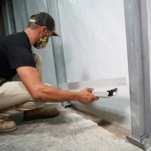 a man installing drainage in a basement
