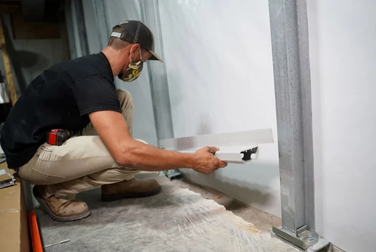 a man installing drainage in a basement