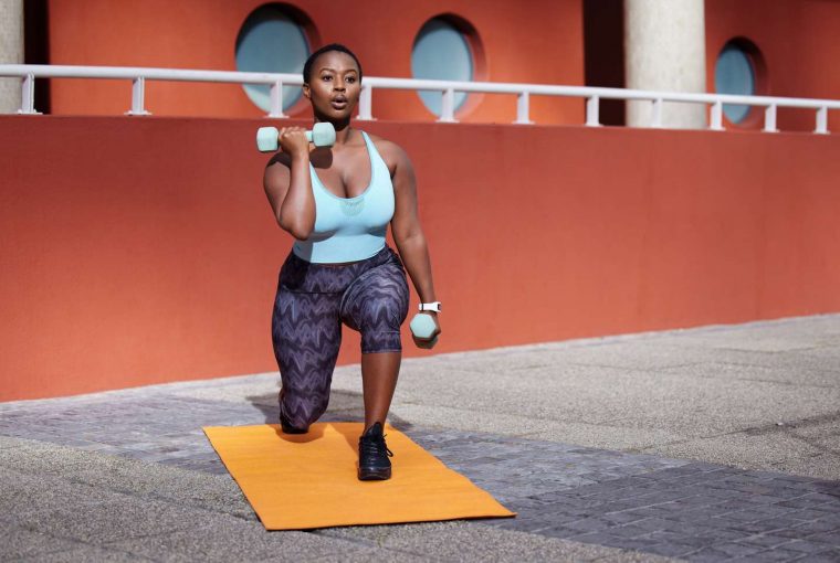 a woman doing dumbell and lunch curls