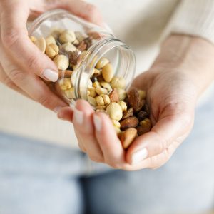 a woman puring a handfull of nuts