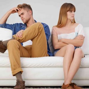 a couple angry at each other sitting on the sofa