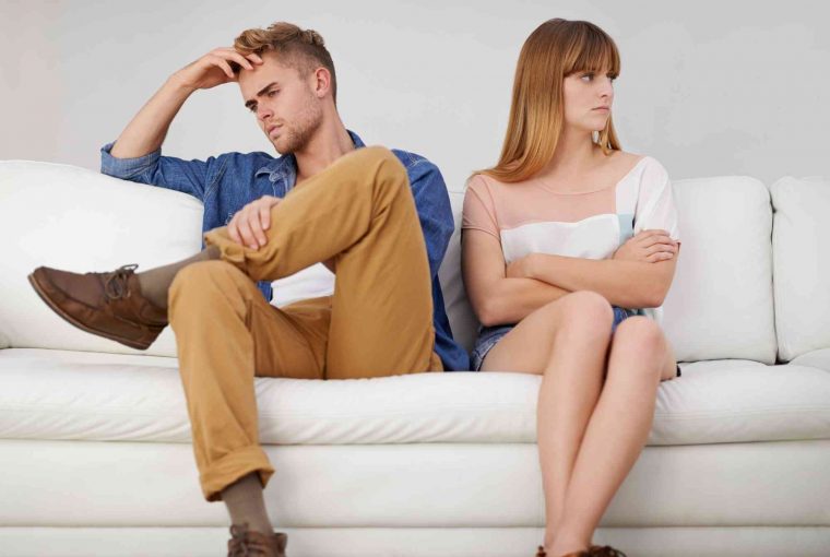 a couple angry at each other sitting on the sofa