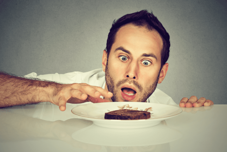 a man trying to eat a brownie