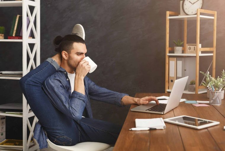a man drinking coffee in front of the computer