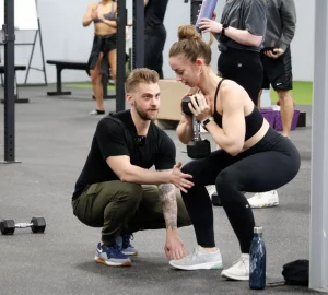 a trainer working with a female client