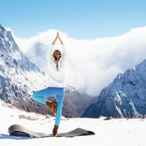 a woman doing a yoga pose in the mountains