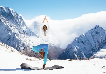 a woman doing a yoga pose in the mountains