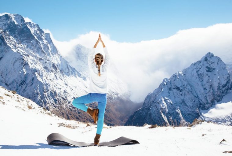 a woman doing a yoga pose in the mountains