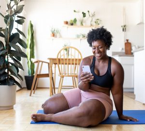 a woman sitting on the floor smiling at her phone