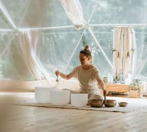 a woman on the floow performing a sound bath
