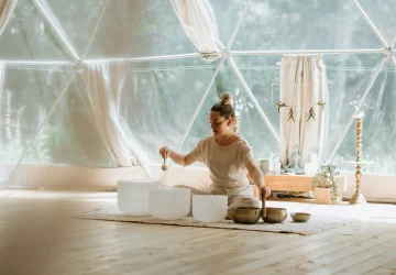 a woman on the floow performing a sound bath