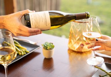 a person pouring a bottle of chardonay