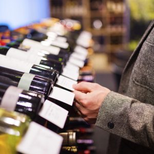 a person in a wine store selecting a good wine