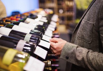 a person in a wine store selecting a good wine