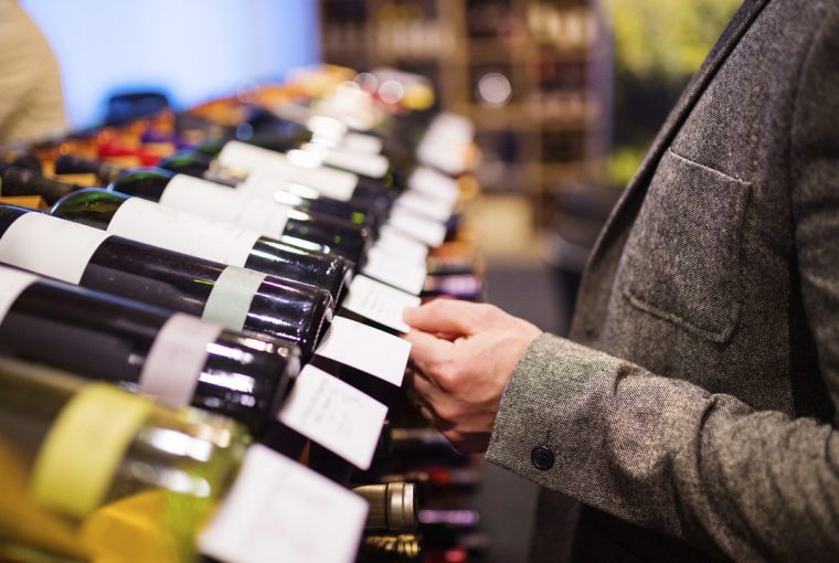 a person in a wine store selecting a good wine