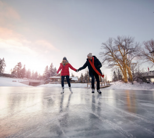a couple skating outdoors in a winter setting