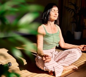a woman meditating in a sunlight room