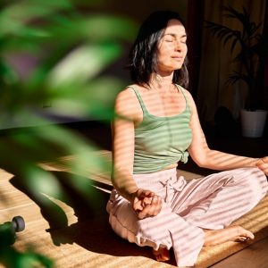 a woman meditating in a sunlight room