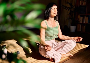 a woman meditating in a sunlight room