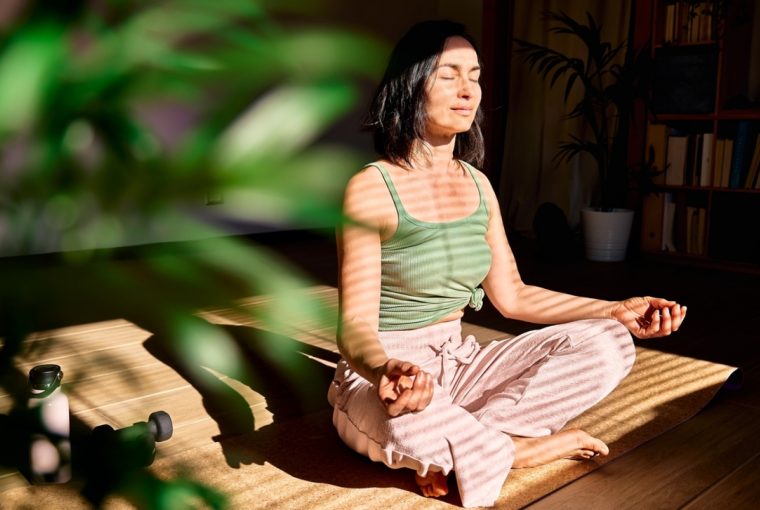 a woman meditating in a sunlight room