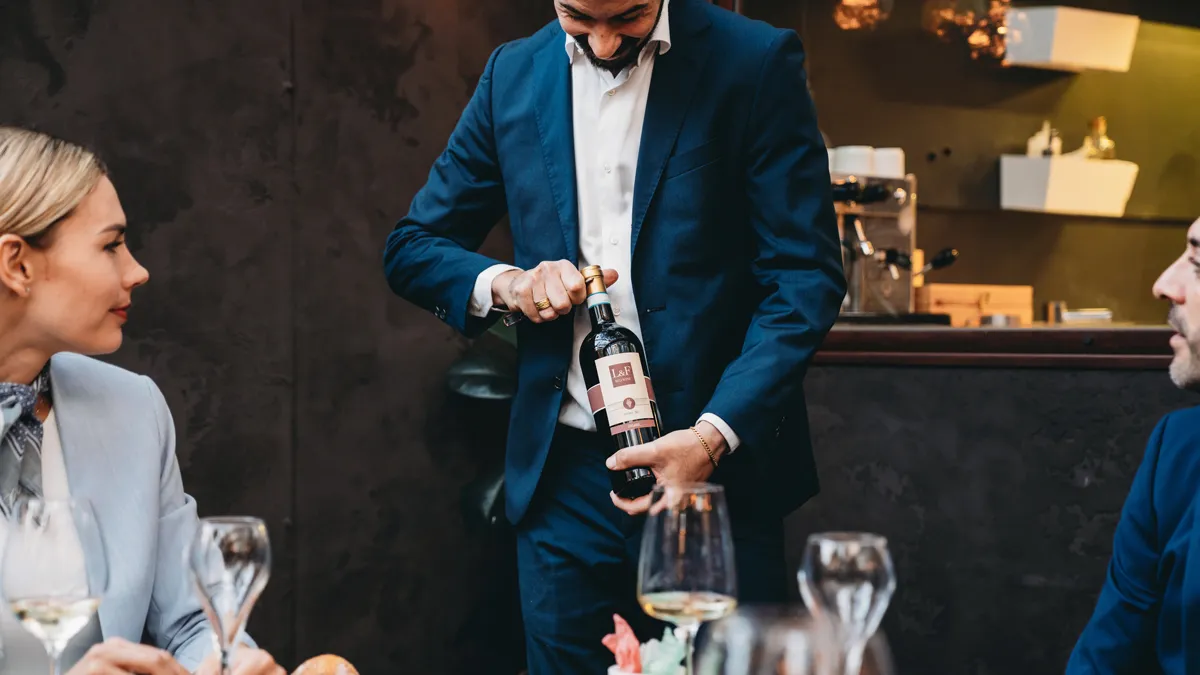 a sommelier opening a bottle of wine